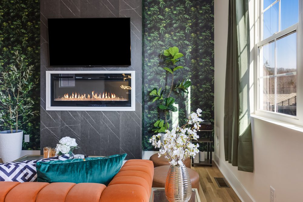 Stylish lounge with sleek fireplace, lush accents and sunlit views