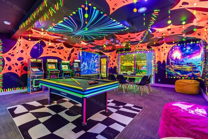 Neon game room with arcade cabinets, a pool table and a checkerboard floor